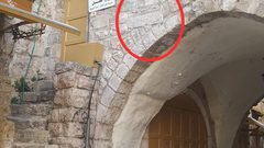 مستوطنون يثبتون حجرًا منقوش عليه الشمعدان بالخليل