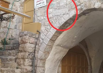 مستوطنون يثبتون حجرًا منقوش عليه الشمعدان بالخليل