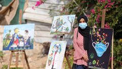فنانون فلسطينيون يحضرون معرضا بعنوان كورونا والفن نظمته قرية الفنون والحرف بغزة