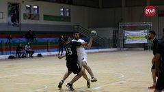 لاعبو كرة يد فلسطينيون من اتحاد دير البلح (أبيض) وخدمة البريج (أسود) يتنافسون خلال نهائي الكأس في صالة سعد صايل للألعاب الرياضية في غزة