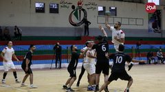 لاعبو كرة يد فلسطينيون من اتحاد دير البلح (أبيض) وخدمة البريج (أسود) يتنافسون خلال نهائي الكأس في صالة سعد صايل للألعاب الرياضية في غزة