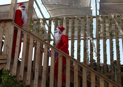 موظفون يرتدون زي "سانتا كلوز" في مقهى على شاطئ مدينة غزة