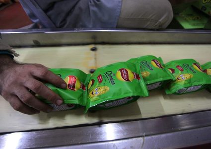 عمال فلسطينيون ينتجون الشيبس في أحد مصانع غزة