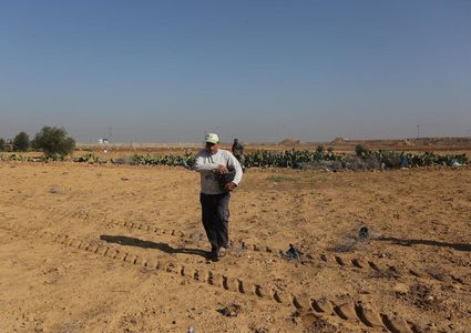 مزارعون يلقون بذور القمح في أراضيهم الواقعة على حدود غزة