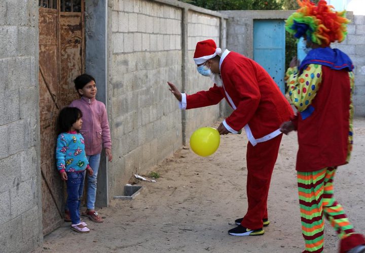 مواطنون يرتدون زي بابا نويل ويوزعون البالونات على الأطفال في خانيونس