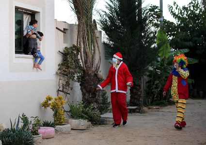 مواطنون يرتدون زي بابا نويل ويوزعون البالونات على الأطفال في خانيونس