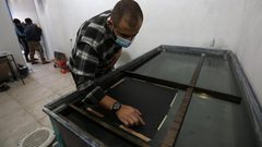 عمر العسولي أول شاب يعمل بالطباعة المائية في قطاع غزة