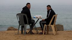 صيادون يعملون على قوارب الصيد الخاصة بهم خلال ضباب كثيف في غزة
