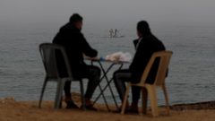 صيادون يعملون على قوارب الصيد الخاصة بهم خلال ضباب كثيف في غزة