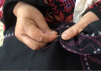 أم بسيل..تنسج حكاية حب الوطن على قطعة قماش