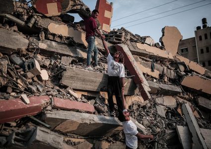 مجموعة من الشبان يمارسون رياضة الباركور على ركام المباني التي دمرها الاحتلال بقطاع غزة