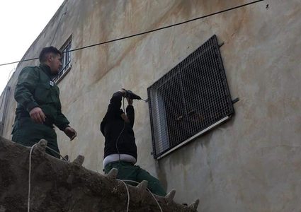 عناصر من الأمن الوطني يركبون حماية لشبابيك منازل المواطنين المحاذية لمستوطنة "شافي شومرون" المخلاة في قرية برقة شمالي مدينة نابلس.