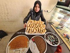 أم الغلابة.. سهير عليوة تعمل في صناعة المعجنات والحلويات وبيعها أمام تجمع مدارس وسط غزة لتعيل أسرتها
