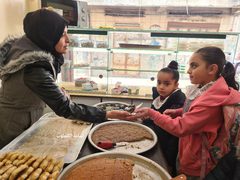 أم الغلابة.. سهير عليوة تعمل في صناعة المعجنات والحلويات وبيعها أمام تجمع مدارس وسط غزة لتعيل أسرتها