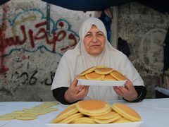 سيدة فلسطينية من غزة تصنع وتبيع القطايف في سوق محلية وسط القطاع
