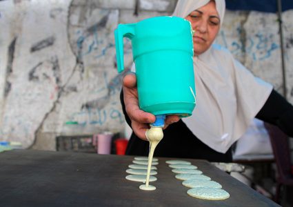 سيدة فلسطينية من غزة تصنع وتبيع القطايف في سوق محلية وسط القطاع