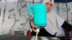 سيدة فلسطينية من غزة تصنع وتبيع القطايف في سوق محلية وسط القطاع