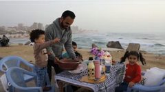 إفطار فلسطيني غزاوي على المقلوبة أمام شاطئ بحر بغزة