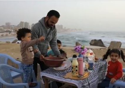 إفطار فلسطيني غزاوي على المقلوبة أمام شاطئ بحر بغزة