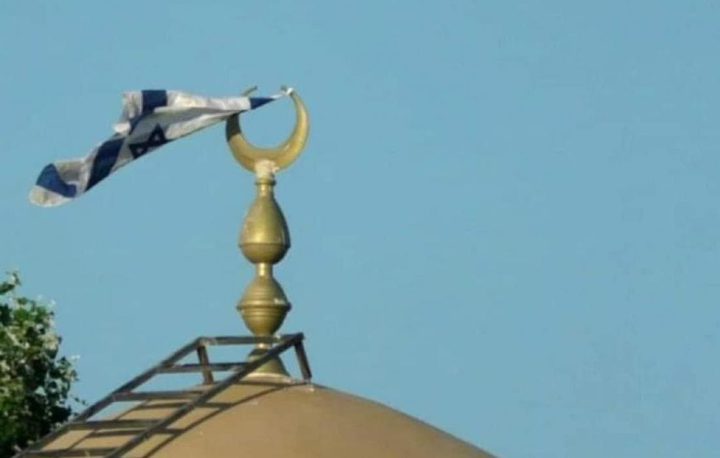 مستوطنون يرفعون أعلاما إسرائيلية فوق مسجد كيسان شرق بيت لحم