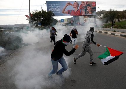 مواجهات بعد إزالة الاحتلال أعلاما فلسطينية في حوارة