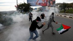 مواجهات بعد إزالة الاحتلال أعلاما فلسطينية في حوارة