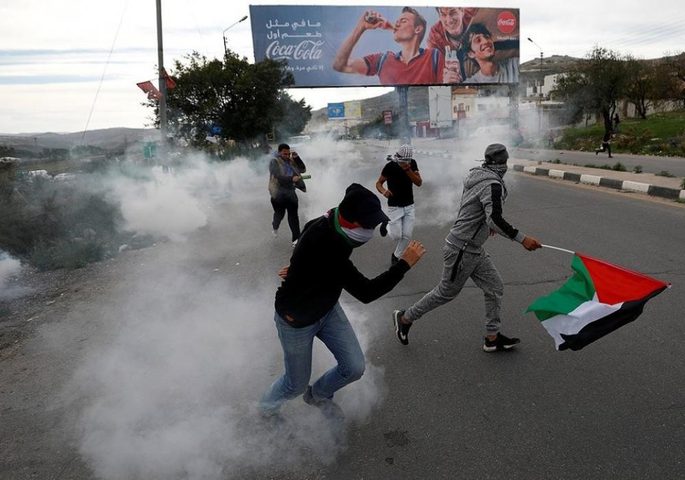 مواجهات بعد إزالة الاحتلال أعلاما فلسطينية في حوارة