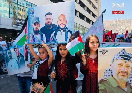 أطفال يرفعون صورا للشهداء خلال فعالية وطنية وسط مدسنة نابلس