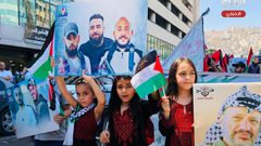 أطفال يرفعون صورا للشهداء خلال فعالية وطنية وسط مدسنة نابلس