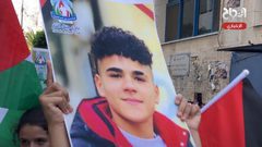 أطفال يرفعون صورا للشهداء خلال فعالية وطنية وسط مدسنة نابلس