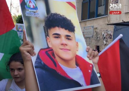 أطفال يرفعون صورا للشهداء خلال فعالية وطنية وسط مدسنة نابلس