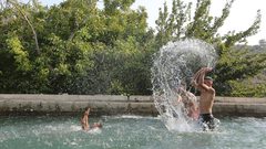 مواطنون يستجمون في عين بوبين التي يحاول المستوطنون الاستيلاء عليها في دير ابزيع غرب رام الله