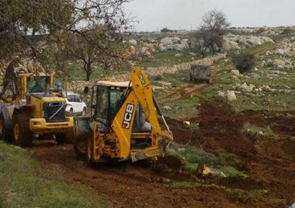 مستوطن يواصل تجريف أراضٍ شمال غرب القدس