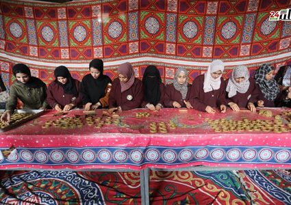 فلسطينيات يشاركن في تحضير الكعك لتوزيعه للمحتاجين، ضمن مبادرة خيرية