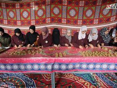فلسطينيات يشاركن في تحضير الكعك لتوزيعه للمحتاجين، ضمن مبادرة خيرية أطلقها تجمع مبادري رفح.