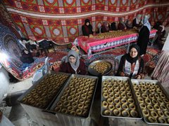فلسطينيات يشاركن في تحضير الكعك لتوزيعه للمحتاجين، ضمن مبادرة خيرية أطلقها تجمع مبادري رفح.