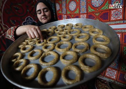 فلسطينيات يشاركن في تحضير الكعك لتوزيعه للمحتاجين، ضمن مبادرة خيرية