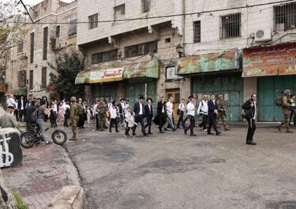 مستوطن ينكل بفلسطيني بحماية الجيش الإسرائيلي