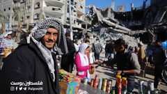 فلسطينيون يتسوقون من سوق مخيم النصيرات بين الدمار والركام