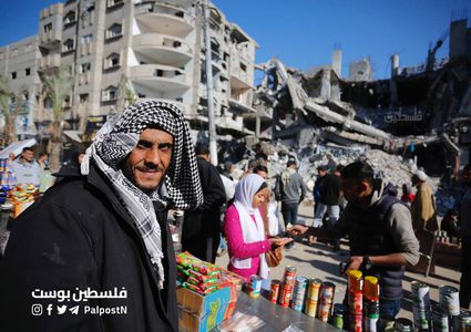 فلسطينيون يتسوقون من سوق مخيم النصيرات بين الدمار والركام