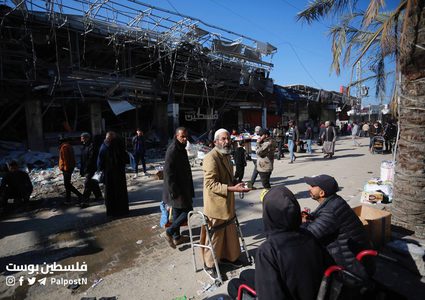 فلسطينيون يتسوقون من سوق مخيم النصيرات بين الدمار والركام
