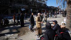 فلسطينيون يتسوقون من سوق مخيم النصيرات بين الدمار والركام