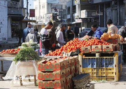 فلسطينيون يتسوقون من سوق مخيم النصيرات بين الدمار والركام