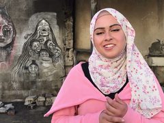 شابة فلسطينية نازحة ترسم أحزان غزة بفحم المواقد على جدران متصدعة