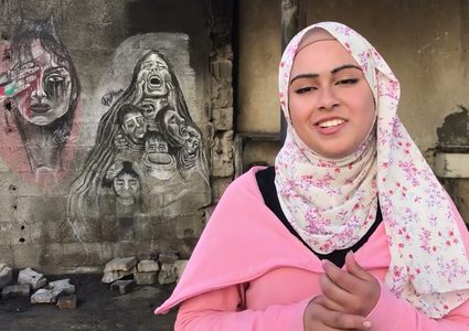 شابة فلسطينية نازحة ترسم أحزان غزة بفحم المواقد على جدران متصدعة