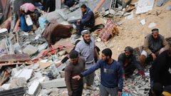 فلسطينيون يحاولون تفقد ما تبقى من منازلهم التي دمرتها غارات الاحتلال الإسرائيلي على دير البلح وسط قطاع غزة.