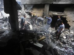 فلسطينيون يحاولون تفقد ما تبقى من منازلهم التي دمرتها غارات الاحتلال الإسرائيلي على دير البلح وسط قطاع غزة.