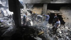 فلسطينيون يحاولون تفقد ما تبقى من منازلهم التي دمرتها غارات الاحتلال الإسرائيلي على دير البلح وسط قطاع غزة.