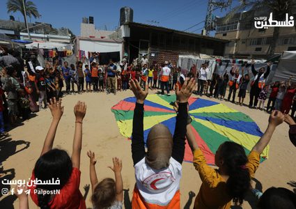 متطوعون فلسطينيون يقومون بحفل ترفيهي للاطفال النازحين داخل خيام النزوح في مشفى شهداء الاقصى بدير البلح وسط قطاع غزة.