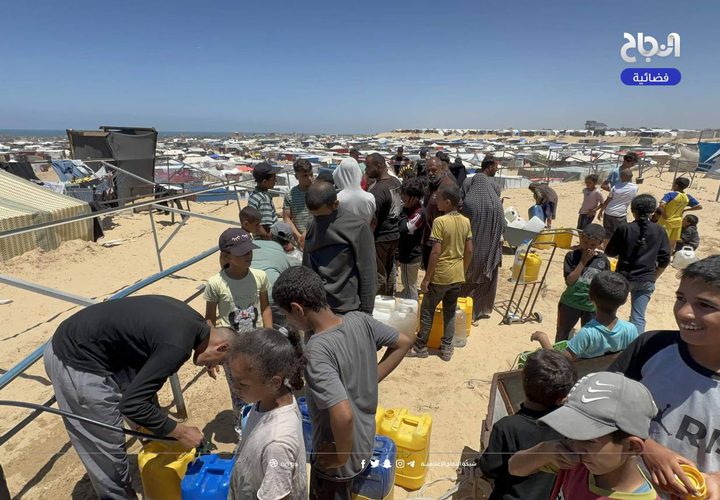 نازحون يتجمعون عند صنبور مياه في منطقة المواصي بمدينة خان يونس